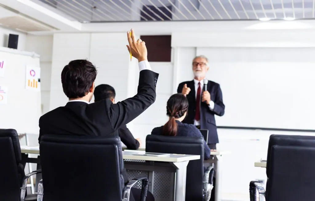 Participant raising a hand during a business training seminar